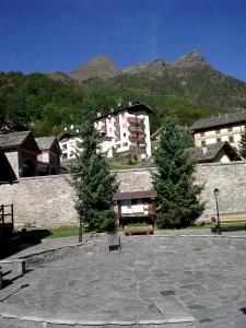 a building with trees in the middle of a courtyard at Pensione Genzianella in Alagna Valsesia