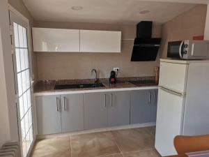 a kitchen with white cabinets and a white refrigerator at Los Cactus in Santa Cruz de Tenerife +7 photos