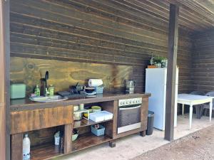 an outdoor kitchen with a counter and a refrigerator at Zelta krasts in Vērgale