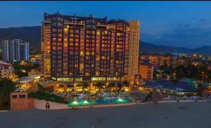 ein großes Hotelgebäude mit Pool bei Nacht in der Unterkunft Zuana Beach Resort -Semana 37 in Playa Dormida