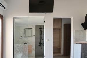Un baño con ducha y un televisor en la pared. en Liofytaki Malia Central Superior Studio 1, en Malia
