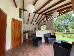 a living room with black chairs and a table at Caribbean Retreats in Cocles