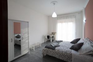 1 dormitorio con 1 cama grande y espejo en B&B Posidonia Salerno, en Salerno
