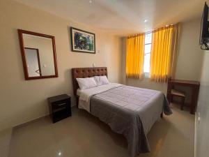 a bedroom with a bed and a mirror and a window at Hotel La Shacsha in Cajamarca