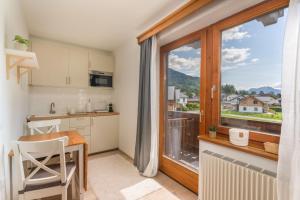 a kitchen with a table and a large window at LOBE Apartment in Bad Mitterndorf