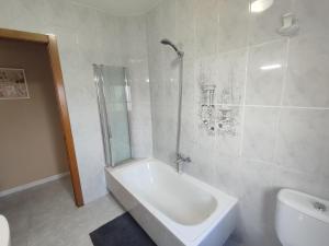 a bathroom with a shower and a tub and a toilet at Apartamento O Cruceiro in A Pobra do Caramiñal +4 photos