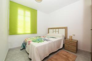 a bedroom with a bed and a window and a dresser at Apartamento O Cruceiro in A Pobra do Caramiñal