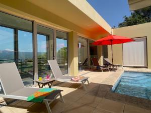 a patio with chairs and an umbrella and a pool at La Beaume in Blauvac