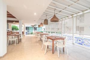 a restaurant with wooden tables and chairs and windows at Hotel San Luis Beach House By OxoHotel in San Andrés