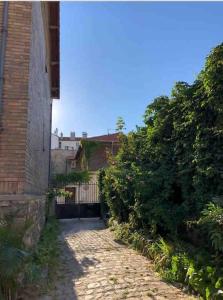 a brick alley way with a building and bushes at M2 Appart 3 chambres 5 min metro - PARC EXPO in Malakoff