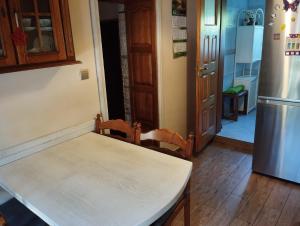 a table and chairs in a kitchen with a refrigerator at Green Hous agroturystyka in Pelnik