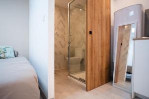 een badkamer met een glazen douchedeur naast een bed bij Appartement L'île Verte à la Ciotat in La Ciotat