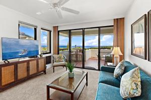 a living room with a blue couch and a tv at Kapalua Golf Villa 23T 4&5 in Kahana