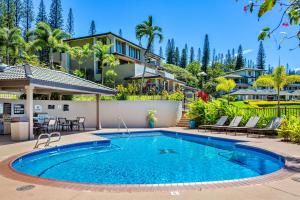 a swimming pool in front of a house at Kapalua Golf Villa 23T 4&5 in Kahana