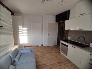 a living room with a couch and a kitchen at Piastów Luna Room in Piastów