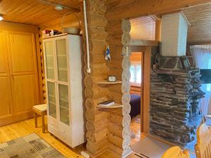 a log cabin with a stone wall at Lapland Chalet Lomalaavu in Suomutunturi