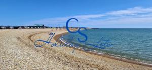 ein Schild an einem Strand mit dem Wort Sucht in der Unterkunft Luke's Hideaway at Seal Bay Resort in Selsey