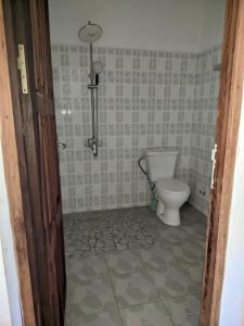 a bathroom with a toilet and a tiled floor at Annexe RAOOF HOTEL in Mahajanga