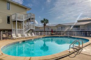 a swimming pool with chairs and a building at Moonraker 25 in Gulf Shores