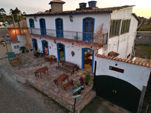 a house with a balcony and a table and benches at Solar Maria Gomes - Lavras Novas MG in Lavras Novas