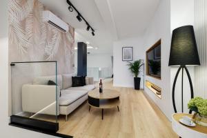 a living room with a white couch and a table at Grand House in Olsztyn