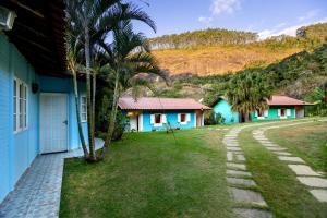 a row of houses with palm trees and a driveway at Pousada Altoé da Montanha in Venda Nova do Imigrante