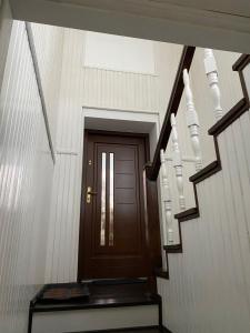 a stairway with a wooden door and a stair case at Apartament M6 w Centrum Wiela in Wiele