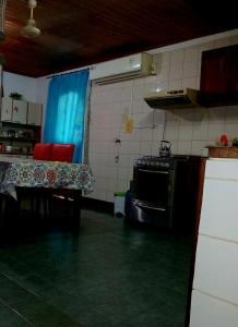 a kitchen with a table with red chairs and a stove at Casa Marconi in Posadas