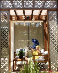 a room with a window with a table and a chair at Hotel Corsica & Spa Serena in Calvi