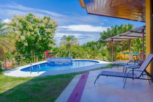 una piscina con dos sillas y una mesa en Casa Wow, en Quepos