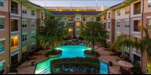 un edificio de apartamentos con una piscina en el centro en Belle Maison near Medical Center NRG Stadium, en Houston