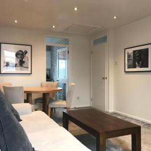 una sala de estar con un sofá y una mesa en Tourist board certified Super city centre apartment with free parking, en Belfast