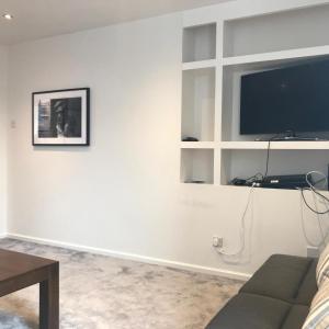 Una sala de estar con un sofá y un televisor de pantalla plana. en Tourist board certified Super city centre apartment with free parking, en Belfast