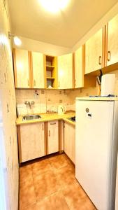 Una cocina con gabinetes de madera y un refrigerador blanco. en Sady Żoliborskie, en Varsovia