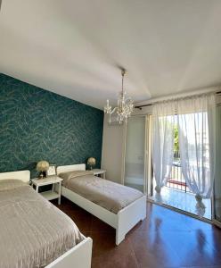 a bedroom with two beds and a chandelier at Loriano Apartment in Capaci