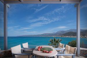 a table on a patio with a view of the ocean at Skajado Holiday Apartments in Stalís
