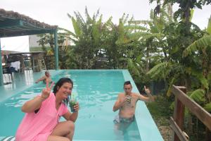 a woman and a man in a swimming pool with drinks at THE RETREAT in Monte Joana