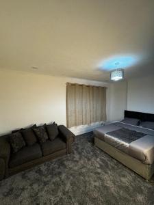 un dormitorio con una cama y un sofá en QD Homes, en Kent