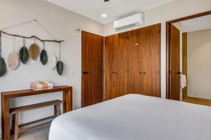 a bedroom with a white bed and a wooden door at Casa Cloud-9 at Maralma in Bucerías +42 photos