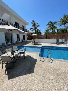 a patio with a table and chairs next to a pool at Frida Kahlo in Bucerías