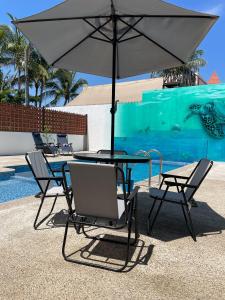 a table and chairs with an umbrella next to a pool at Frida Kahlo in Bucerías