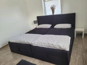a bed with a black bed frame in a bedroom at Perle 110 in Bad Zwischenahn