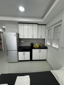 a kitchen with white cabinets and a black counter top at Apartmani MILIC in Kotor