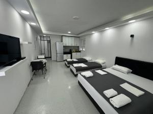 a room with three beds and a flat screen tv at Apartmani MILIC in Kotor