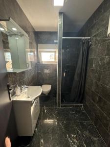 a bathroom with a shower and a sink and a toilet at Apartmani MILIC in Kotor +22 photos