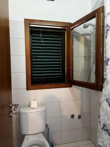 a bathroom with a toilet with a window and a shower at Guesthouse Ale&Ale in Tale