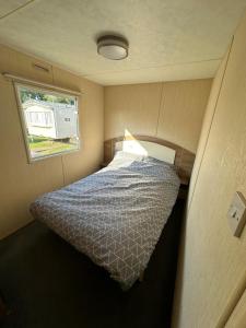 a bed in a small room with a window at Seawick Holiday Home Horizon 363 in Saint Osyth