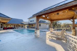 a patio with a pool and a wooden pavilion at Double Shotz in Concan