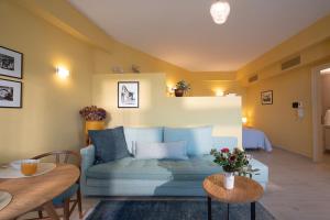 a living room with a blue couch and a table at Ostria Studio, Kyparissia OldTown Home Collection in Kyparissia