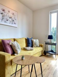ein Wohnzimmer mit einem gelben Sofa und einem Tisch in der Unterkunft 5 Sterne Apartment, Nähe Flughafen Berlin, WLAN in Schönefeld